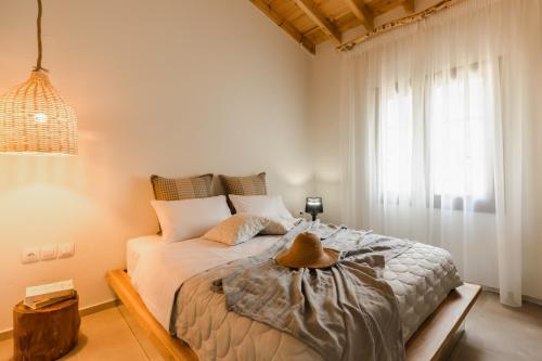 a bedroom with a bed with a hat on it at Mystes in Samothráki