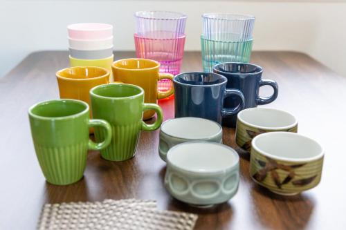 a group of different colored cups sitting on a table at KOSHIGOE seaside inn in Kamakura