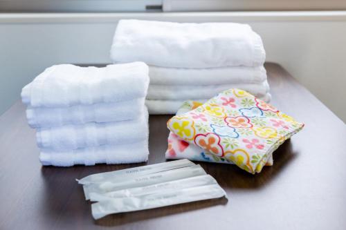 a table topped with towels and a pile of towels at KOSHIGOE seaside inn in Kamakura