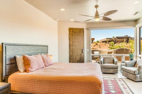 a bedroom with a bed and a couch and a fan at Entrada Casita with a View in St. George