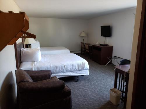Roundup的住宿－Autumn's Inn，配有一张床和一把椅子的酒店客房