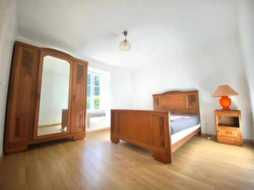 een slaapkamer met een bed, een dressoir en een spiegel bij Spacieuse maison dans un parc privée in Vareilles