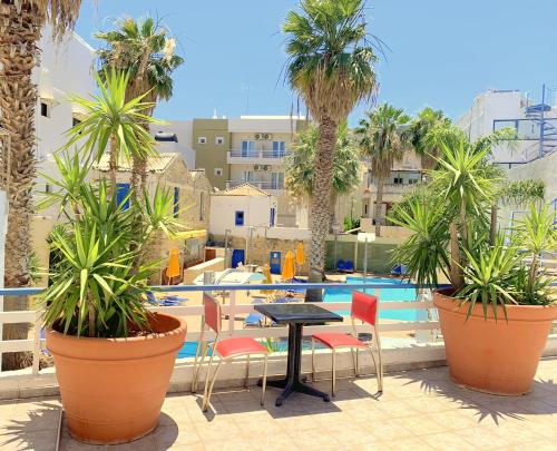 a patio area with tables, chairs and umbrellas at Kassavetis Center - Hotel Studios & Apartments in Hersonissos