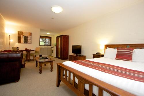 a bedroom with a bed and a living room at Grosvenor Court Apartments in Hobart