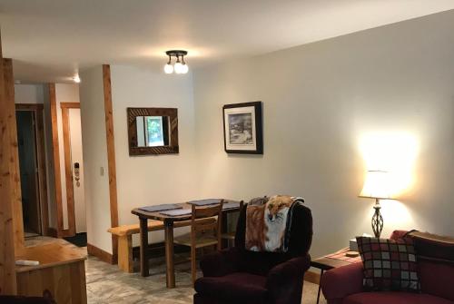 a living room with a table and a chair at Mountain Breeze Getaway Condos in Warren