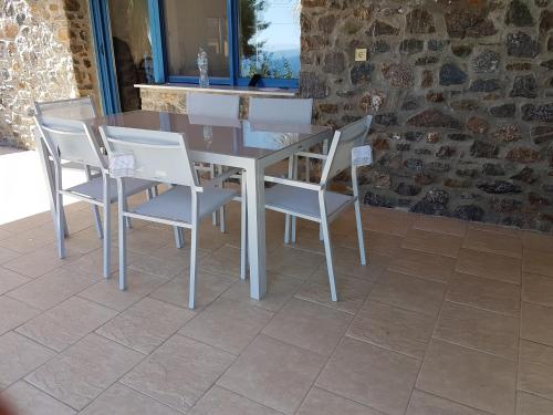 a dining room table and chairs on a patio at PANORAMA HOUSE in Metókhion Konstamonítou