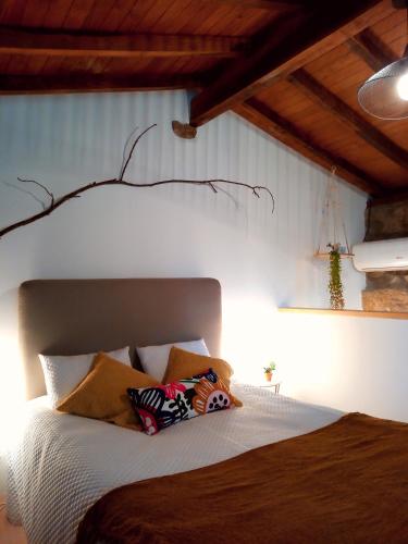 a bedroom with a bed with pillows on it at Casa da Carvalheira in Parada