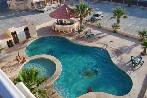 an overhead view of a large swimming pool with palm trees at Hotel Plaza Peñasco in Puerto Peñasco