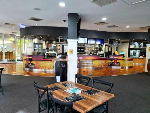 ein Restaurant mit einem Tisch und Stühlen sowie einer Bar in der Unterkunft Madison Tower Mill Hotel in Brisbane
