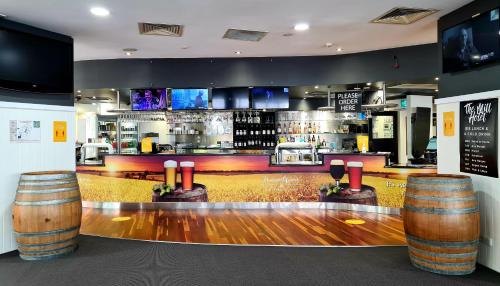 a bar with wooden floors and a counter with barrels at Madison Tower Mill Hotel in Brisbane