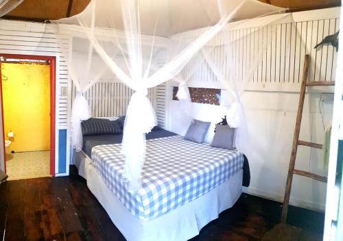 1 dormitorio con 1 cama blanca con dosel en Kohchang 7 Guest House en Ko Chang