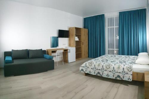 a bedroom with a bed and a couch and a desk at Zatokas Sun Club in Zatoka