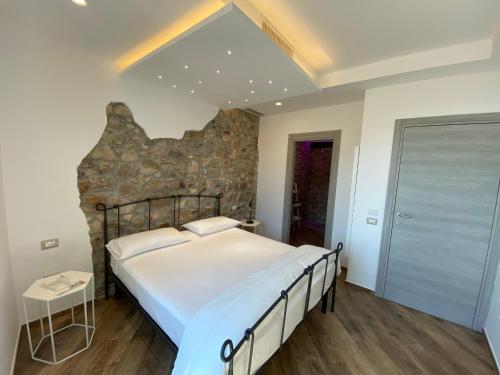 a bedroom with a large bed and a stone wall at L'Orologio Bed & Breakfast in Capaccio-Paestum