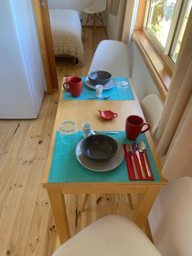 a small table with plates and cups on it at Moana Beach Sunset Holiday Accommodation A in Moana