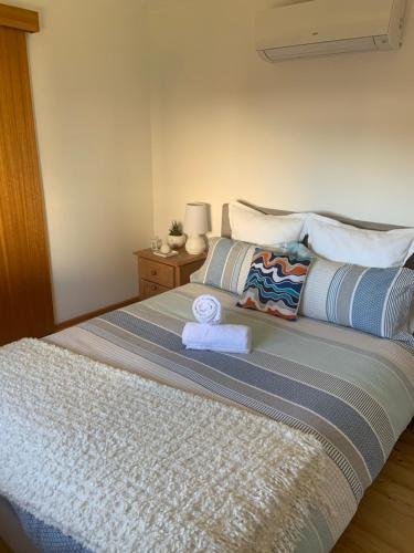ein Schlafzimmer mit einem Bett mit zwei Handtüchern darauf in der Unterkunft Moana Beach Sunset Holiday Accommodation A in Moana