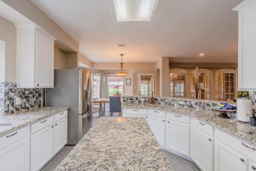 a kitchen with white cabinets and granite counter tops at Frisco finest home, large, pool, no parties! in Frisco