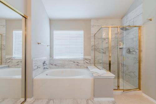 a white bathroom with a tub and a shower at Frisco finest home, large, pool, no parties! in Frisco