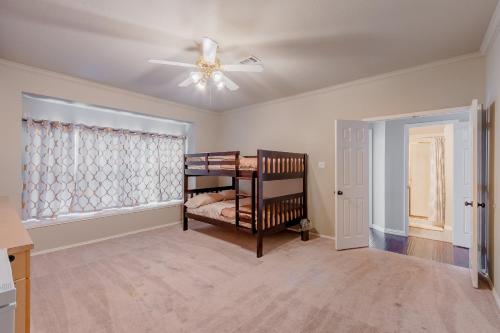 a bedroom with a bunk bed and a ceiling fan at Frisco finest home, large, pool, no parties! in Frisco