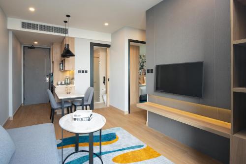 a living room with a couch and a tv at Holiday Inn & Suites Siracha Laemchabang by IHG in Si Racha