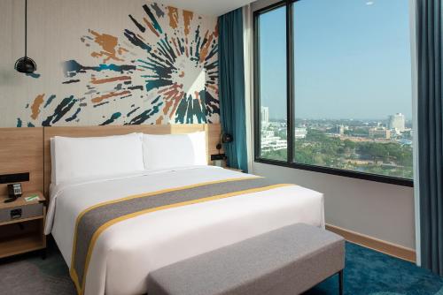 a bedroom with a bed and a large window at Holiday Inn & Suites Siracha Laemchabang by IHG in Si Racha