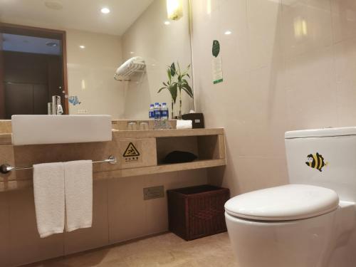 a bathroom with a white toilet and a sink at Holiday Inn Xiaoshan by IHG in Hangzhou