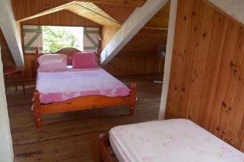a bedroom with two beds in a wooden cabin at LE VILLAGE DE CANADA in Faup