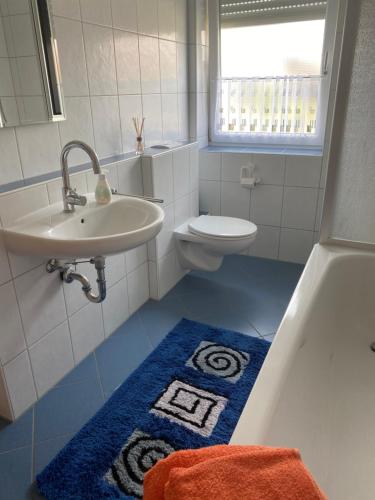 uma casa de banho com um lavatório, uma banheira e um WC. em Schwarzwaldidylle em Waldachtal