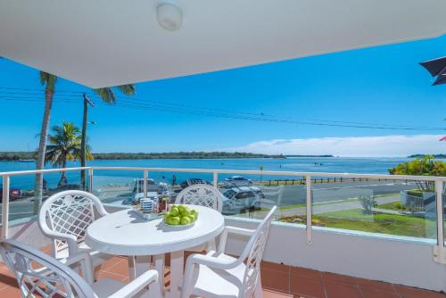een balkon met een tafel en stoelen en uitzicht op de oceaan bij Munna Beach Apartments in Noosaville