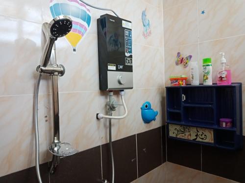a shower in a bathroom with a pay phone at Inapan Desa Homestay Kangar Perlis in Kangar