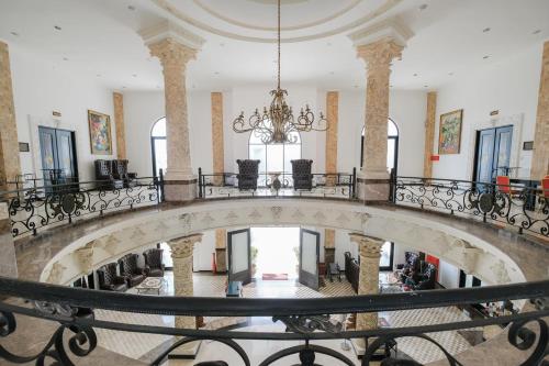 an ornate staircase in a building with a chandelier at The Grand Palace Hotel Yogyakarta in Yogyakarta