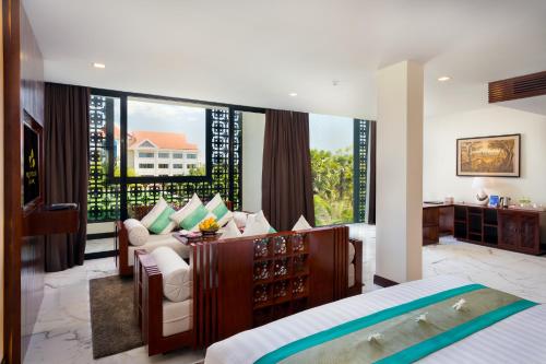 um quarto com uma cama e uma secretária em Lotus Blanc Resort em Siem Reap