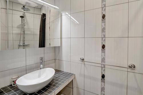 une salle de bain blanche avec un lavabo et une douche dans l'établissement Le Well Done - Joli T2 avec terrasse, à Bordeaux