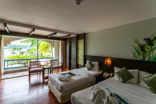 a hotel room with two beds and a balcony at Phi Phi Island Cabana Hotel in Phi Phi Don