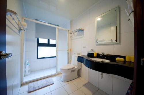 ein Bad mit einem WC, einem Waschbecken und einer Dusche in der Unterkunft Ken's Joy Inn in Kaohsiung
