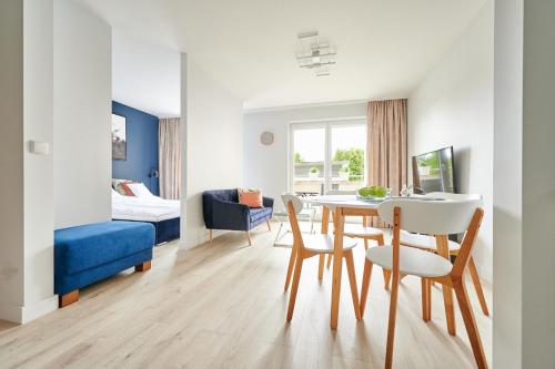 a living room with a table and chairs and a bedroom at Apartament Dwa Jeziora in Olsztyn