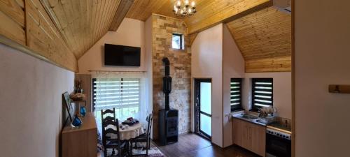 a kitchen with wooden ceilings and a room with a stove at Conacul Caterinei in Polovragi
