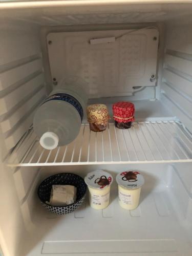 a refrigerator with a bottle of water and some food at Escale beauté le Crotoy in Le Crotoy
