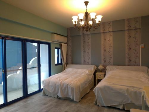a bedroom with two beds and a chandelier at 蓋雅之都民宿 in Taitung City
