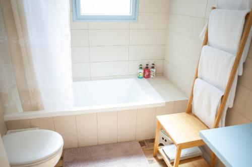 a bathroom with a toilet and a bath tub at Olive - Israeli Zimmer in Bet Hillel