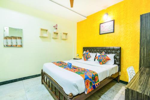 a bedroom with a bed with a yellow wall at Royal Palace Marina in Chennai