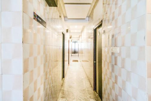 an empty corridor in a building with tiled walls at Royal Palace Marina in Chennai