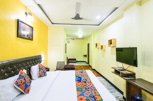 a room with a bed and a flat screen tv at Royal Palace Marina in Chennai