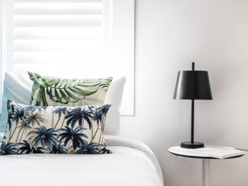 a bedroom with a bed with a pillow and a lamp at The Baxley Bondi in Sydney