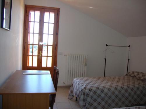 プティニャーノにあるAl Boschettoのベッドルーム1室(ベッド1台、テーブル、窓付)