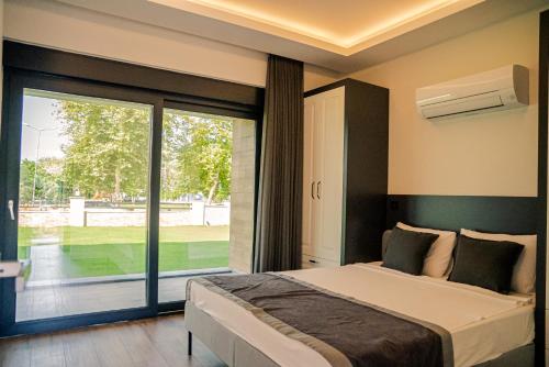 a bedroom with a bed and a sliding glass door at Sweet Home Kemer Apartments in Kemer