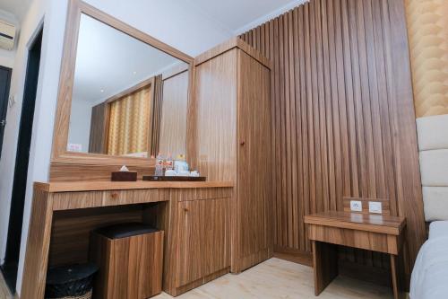 a bathroom with a sink and a mirror in a room at The Grand Palace Hotel Yogyakarta in Yogyakarta