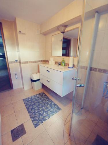 a bathroom with a sink and a shower with a mirror at Dąbrowski in Nadarzyn