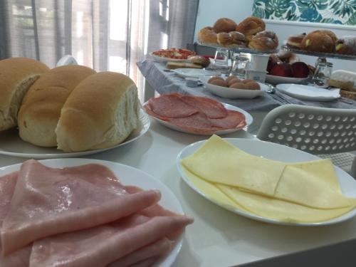 a table topped with plates of bread and meat and cheese at Maison De luxe in Pompei