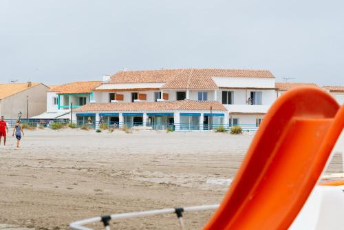a slide on the beach with houses in the background at Hôtel Casa Marina in Saintes-Maries-de-la-Mer