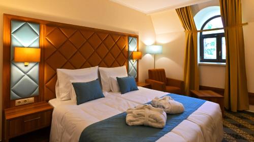 a hotel room with a bed with towels on it at Wellness Hotel Gyula in Gyula